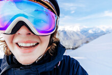 Happy Woman Wearing Ski Goggles In Winter