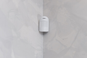 Modern motion sensor on wall indoors. Close-up