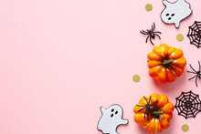 Happy Halloween Concept. Flat Lay Composition With Cute Ghosts, Orange Pumpkins, Spiders, Confetti On Pink Background. Top View, Copy Space.
