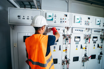 Wall Mural - Adult electrician builder engineer testing and screwing equipment in fuse box and repairing of modern electricity power station using voltmeter. Automatic control cabinet