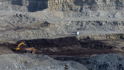 Panoramic aerial view of coal mine. Open pit mine industry, big yellow mining truck for coal quarry. Open coal mining anthracite mining. Pit on coal mining by open way. 