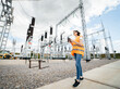 © andrew_shots - Adult woman energy engineer inspects the equipment of the modern power station using data from the tablet. Power engineering.