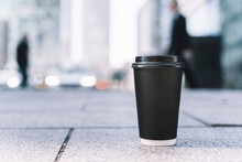 Takeaway Coffee In A Paper Cup. Hot Drink To Go On The Background Of A Busy City Street. Paper Cup Mockup