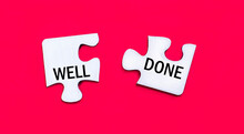 On A Bright Red Background, Two White Puzzles With The Text WELL DONE. View From Above.