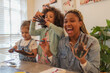 © Caia Image - Happy playful mother and daughters finger painting