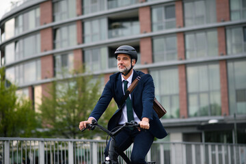 Businessman commuter on the way to work, riding bike in city, sustainable lifestyle concept.