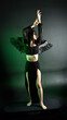 © faestock - portrait of beautiful asian model with dark hair, wearing black gothic skirt costume, angel feather wings with horned headdress. Posing with gestural hands  on dark silhouette  studio background.