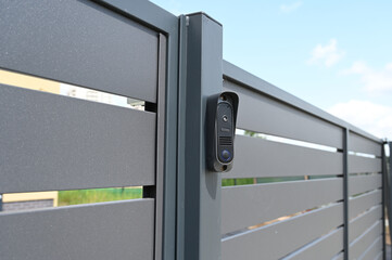 black intercom call panel on a mounted in panel fence in anthracite color, visible wicket.entrance t