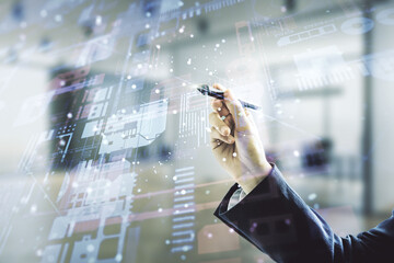 Man hand with pen working with abstract virtual coding illustration on blurred office background, software development concept. Multiexposure