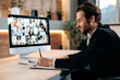 © Kateryna - Caucasian business man, conducts a brainstorm with multiracial business team, discussing financial strategy and analyzing risks. Communication by video conference, financial briefing, notes
