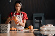 © Drobot Dean - Young hispanic woman peeling sweet potato while cooking in kitchen