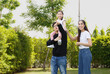 © atitaph - Asian family happy bright cute daughter is resting by playing in the grass let daughter ride father's neck