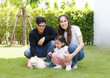 © atitaph - Asian family is happy, bright, cute, daughter is relaxing, playing with the dog in the grass