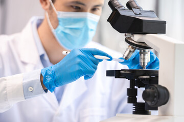 Wall Mural - biotechnology scientist using scientific microscope for research in biology medicine laboratory, equ