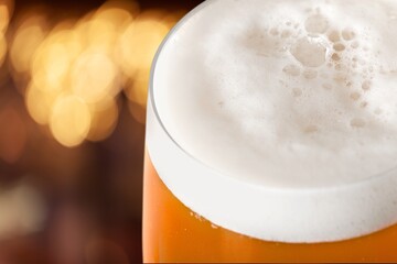 Canvas Print - Beer is poured  into beer glass.  Lager beer foams and pours from bottle into glass.