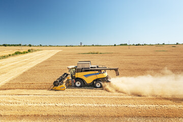 Aufkleber - DCombine harvester on a wheat field with blue sky.
