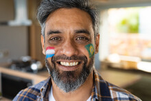 Portrait Of Happy Biracial Man With Flags Of Netherlands And Brazil On His Cheeks