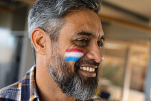 Happy Biracial Man With Flag Of Netherlands On His Cheek