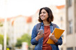 © Prostock-studio - Cheerful Arab Female Student With Smartphone And Workbooks Standing Outdoors