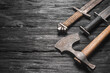 Ancient swords and axe on the black wooden table flat lay background with copy space.