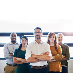 Portrait of a group of confident and serious professionals standing together with arms crossed and copyspace. Serious team leader, manager or entrepreneur leading with support of staff and colleagues