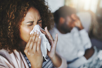 ill or sick woman with allergy, sinus infection sneezing in tissue or blowing nose during flu season