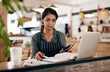 © Nicholas Felix/peopleimages.com - Cafe owner with laptop, phone and book checking online order, searching available bookings and preparing takeaway deliveries coffee shop. Serious local restaurant entrepreneur pricing a menu on tech