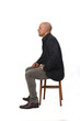 © Curto - side view of a full portrait of a man sitting on chair with cross-legged on white background
