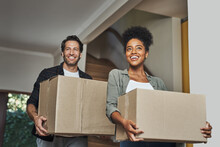 New House, Moving And Happy Couple Carrying Boxes While Feeling Proud And Excited About Buying A House With A Mortgage Loan. Interracial Husband And Wife First Time Buyers Unpacking In Dream Home