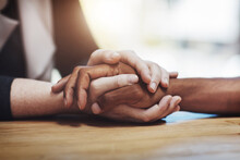 Support, Compassion And Trust While Holding Hands And Sitting Together At A Table. Closeup Of A Loving, Caring And Interracial Couple Or Friends Comforting Each Other After A Loss Or Cancer News