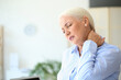 © Pixel-Shot - Mature businesswoman suffering from neck pain in office