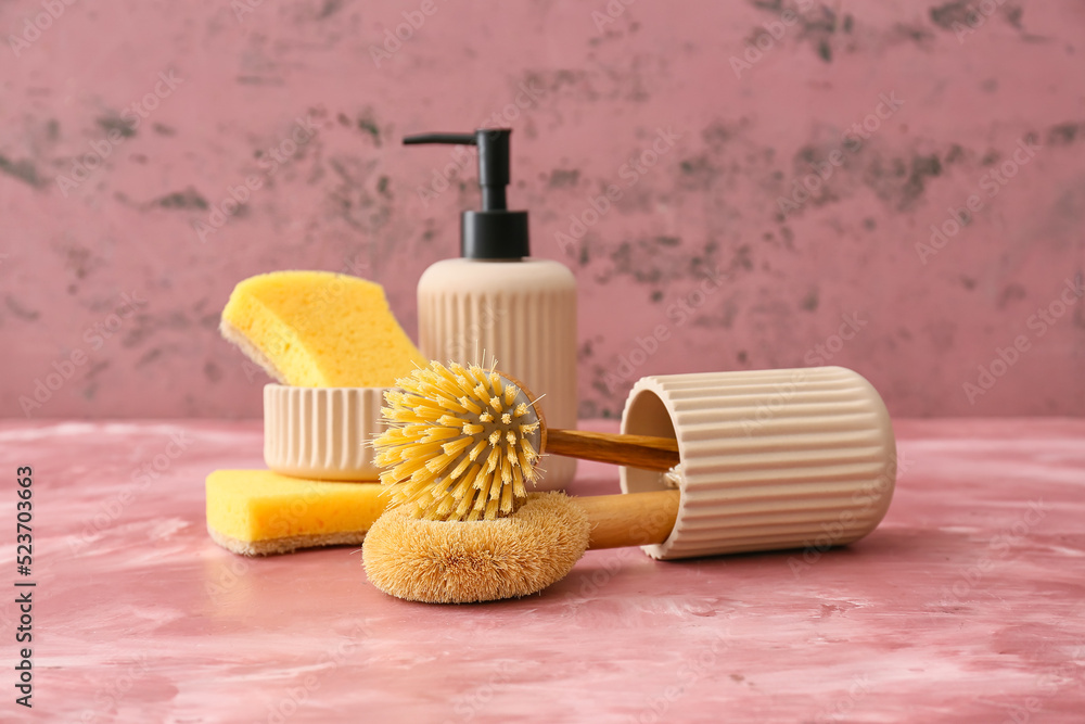 Cleaning supplies and pump bottle on color background