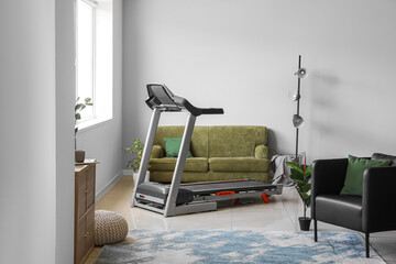 Wall Mural - Interior of light living room with treadmill and sofa