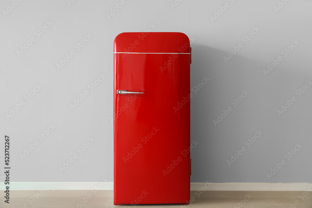 Stylish retro fridge near light wall