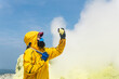 © Evgeny - woman volcanologist on the background of a smoking fumarole examines a sample of a sulfur mineral