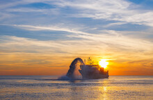 Vessel Engaged In Dredging At Sunset Time. Hopper Dredger Working At Sea. Ship Excavating Material From A Water Environment. Beautiful Sunset, Baltic Sea