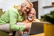 © Zoran Zeremski - Senior couple at home spending time together using laptop.