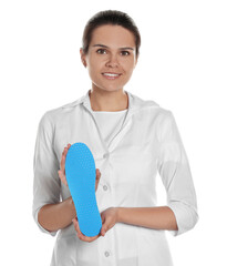 Wall Mural - Beautiful female orthopedist showing insole on white background