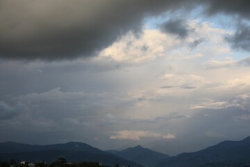Wall Mural - picturesque view of sky with beautiful clouds above green hills