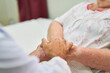 © Robert Kneschke - Nurses holding hands for comfort in the hospice