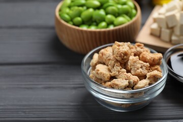 Dehydrated soy meat and other organic products on grey wooden table, closeup. Space for text