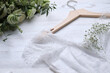 Leinwandbild Motiv Beautiful wedding dress and flowers on white wooden background, closeup