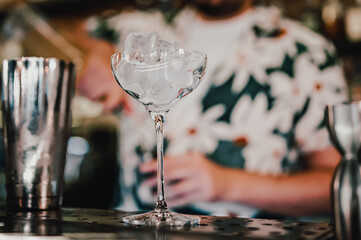 Ice cube in an empty glass on a bar counter in bar or pub