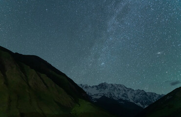 Wall Mural - beautiful snow covered mountain in the starry night with milky way galaxy.