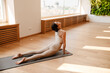 © Drobot Dean - Young white woman doing exercise on mat during yoga practice
