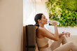 © Drobot Dean - Young white woman drinking water during yoga practice