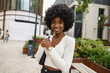 © fotofabrika - Portrait of young african woman with afro hairstyle smiling in urban background