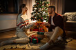 © Syda Productions - holidays, celebration and people concept - happy couple with christmas gift at home