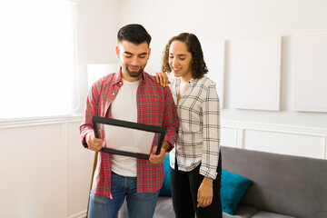 Wall Mural - Lovely couple looking at a family picture frame