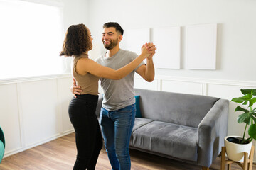 Wall Mural - Happy couple dancing with romantic music around the living room